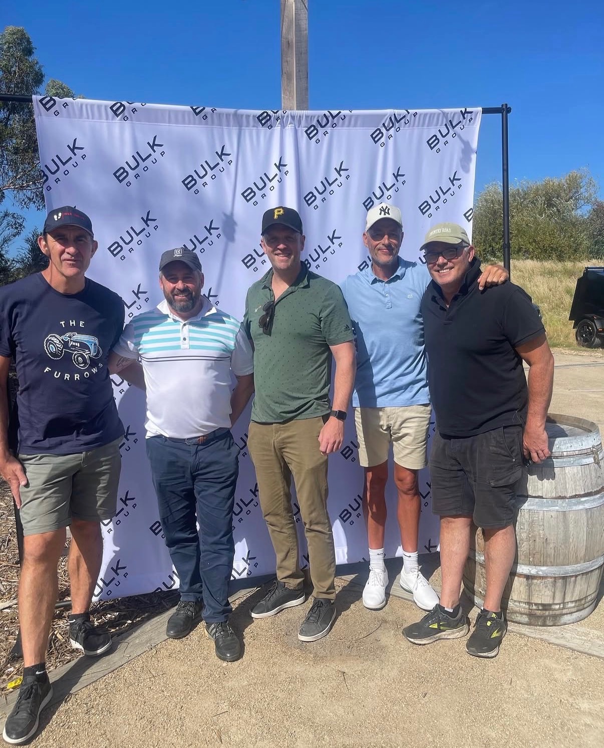 Guests in front of branded sponsor signage at a 4QTR golf day